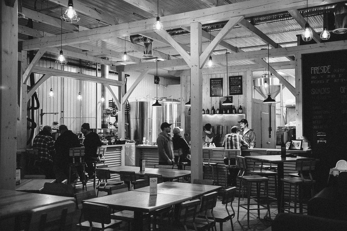 Guests gathering in the timber-frame Snake Lake taproom