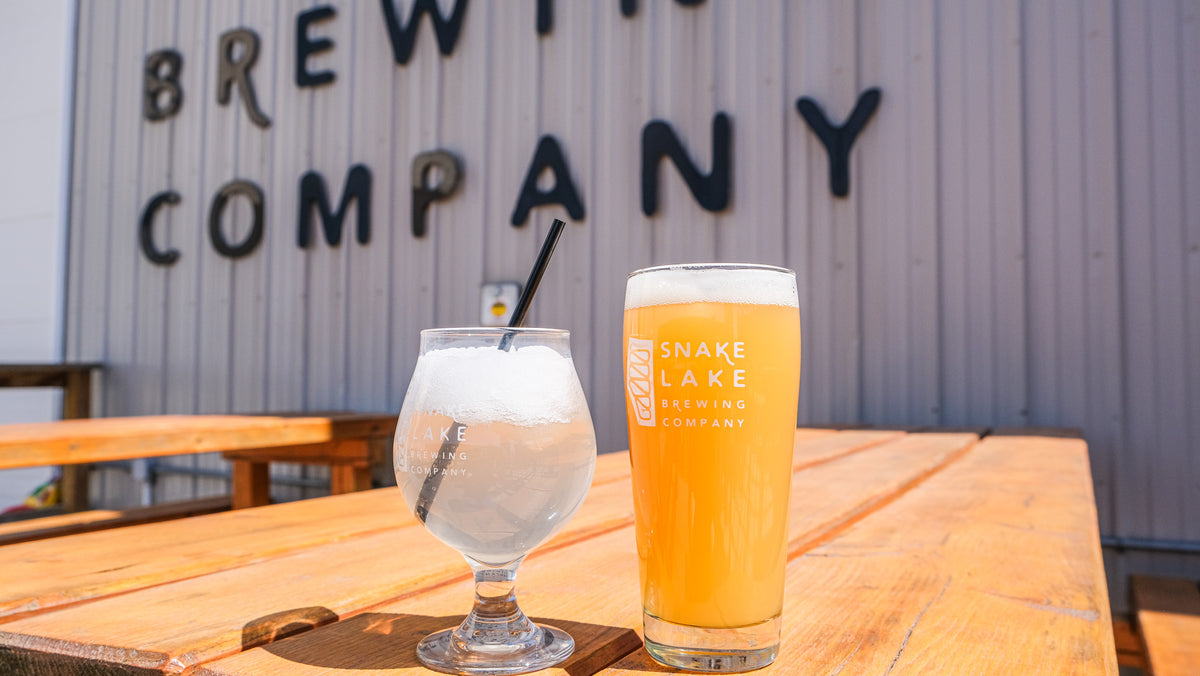 Snake Lake beer and a cocktail on a sunlit patio table